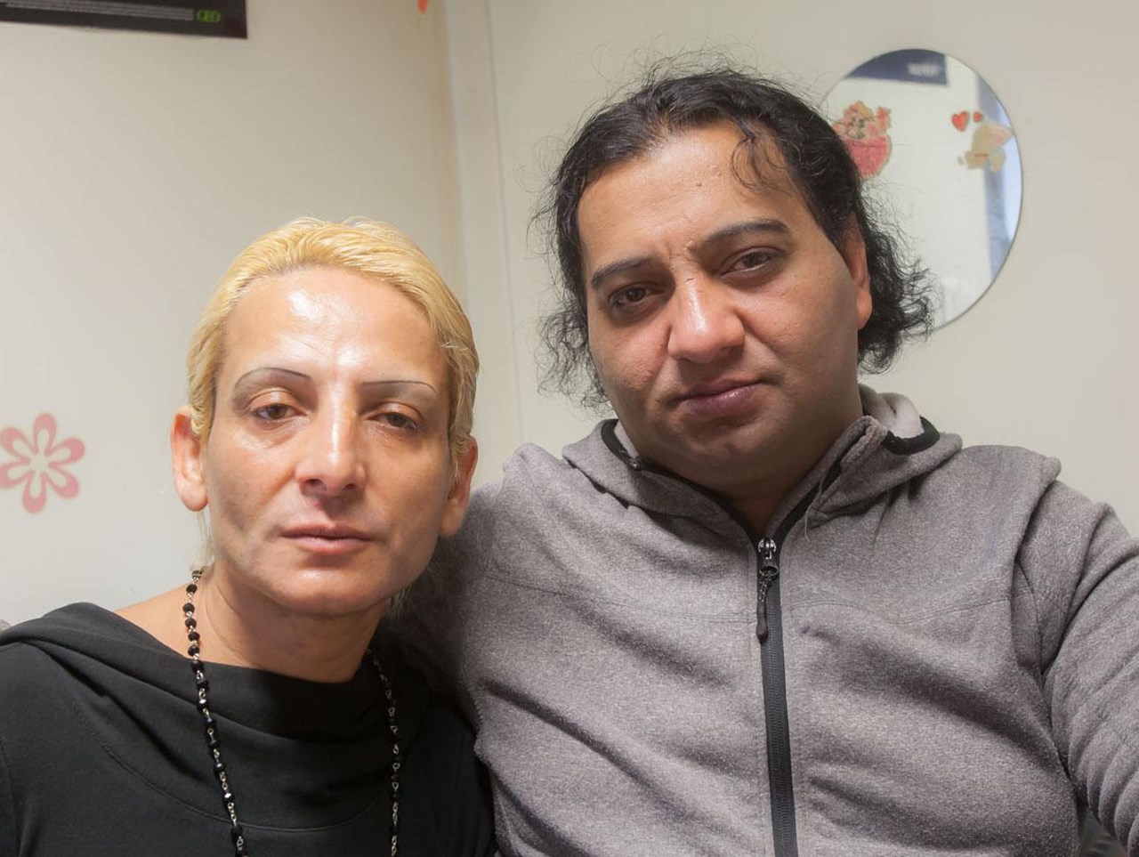 Zwei Frauen sitzen Arm in Arm nebeneinander
