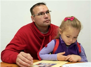 Mann mit Kind Vater sitzt mit Tochter am Tisch